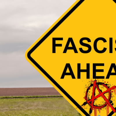 A field in the background with a yellow road sign that says "Fascism Ahead" and at the bottom of the sign is a anarchy symbol - a red A in a circle.